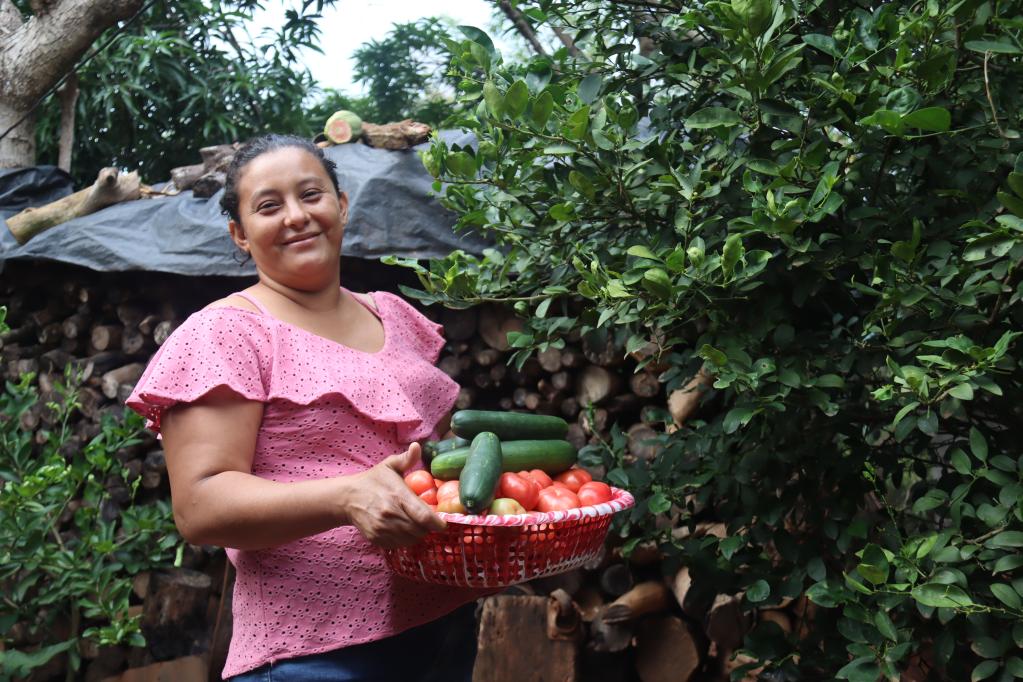 Fotografía de Nelly, mostrando las hortalizas que cultiva