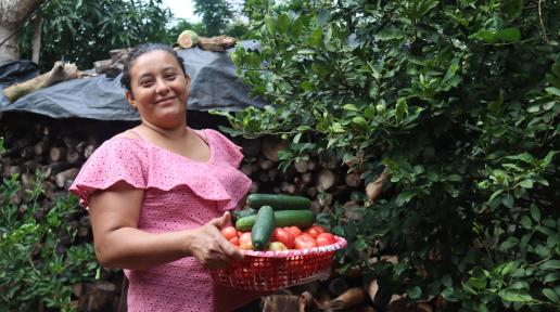 Fotografía de Nelly, mostrando las hortalizas que cultiva